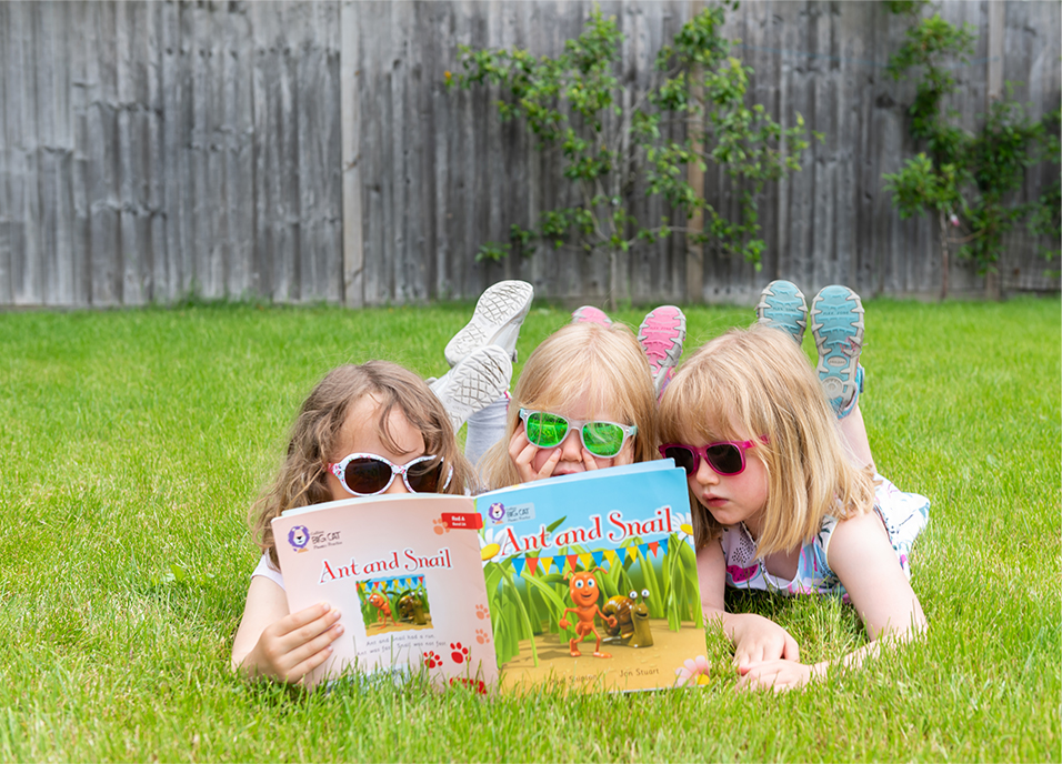 children reading books together in the garden