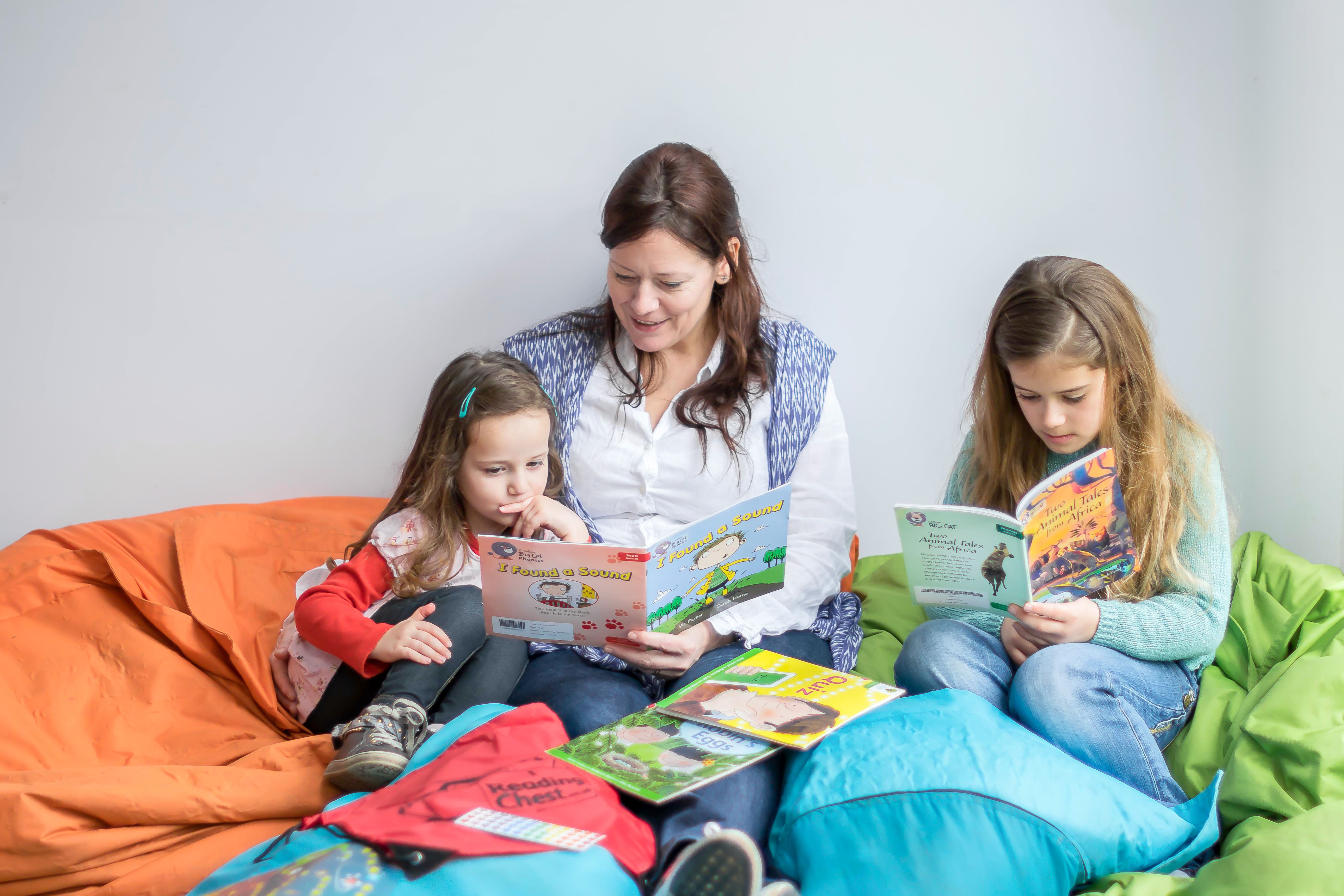two children reading with their mum on beanbags