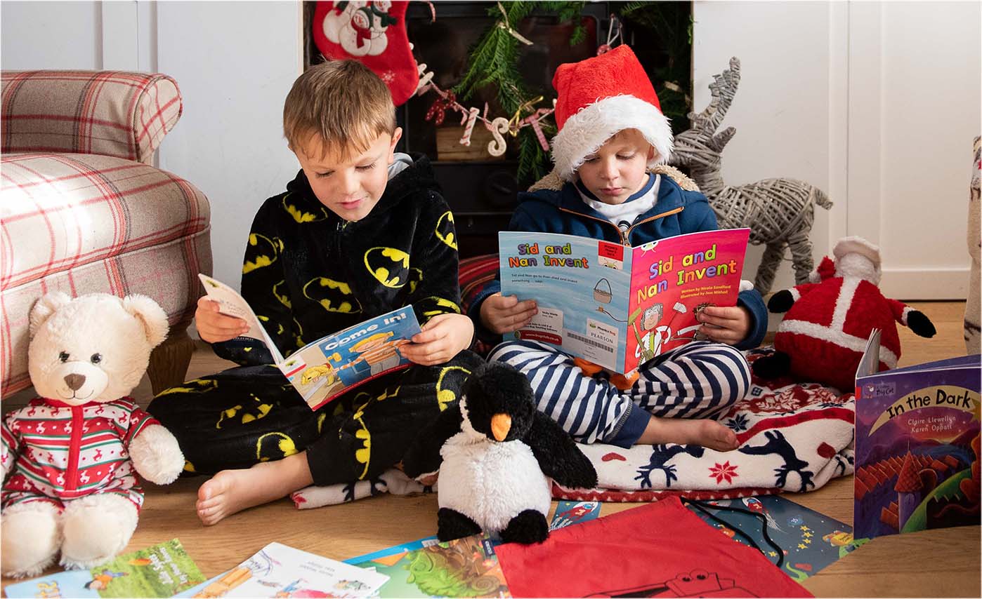 kids reading books under a christmas tree